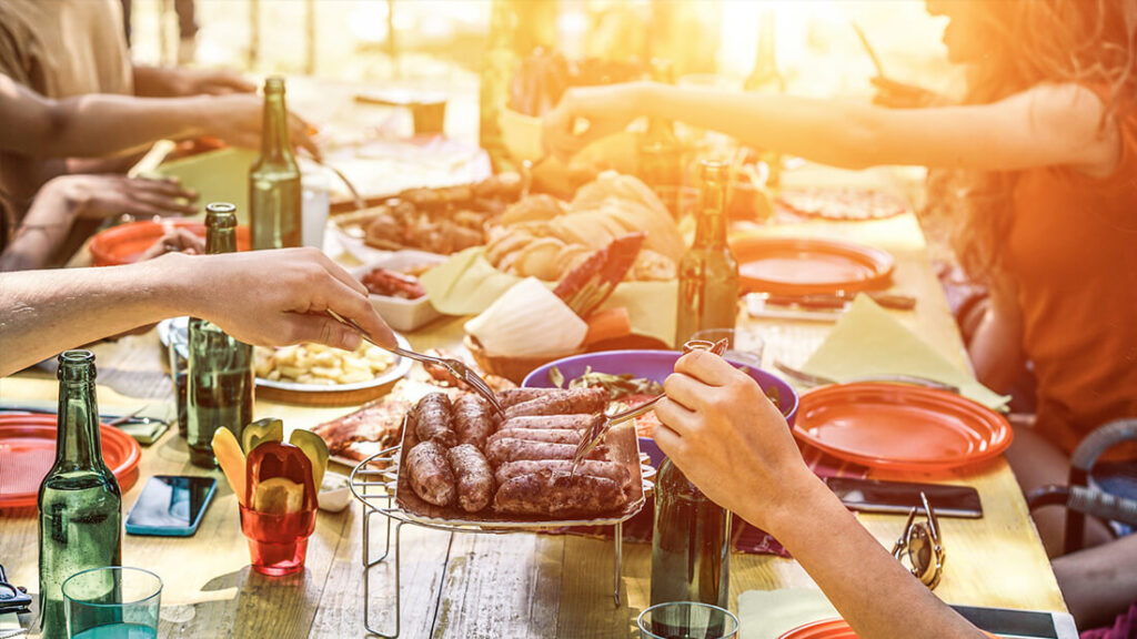 A group of people sitting at a table with plates and food.