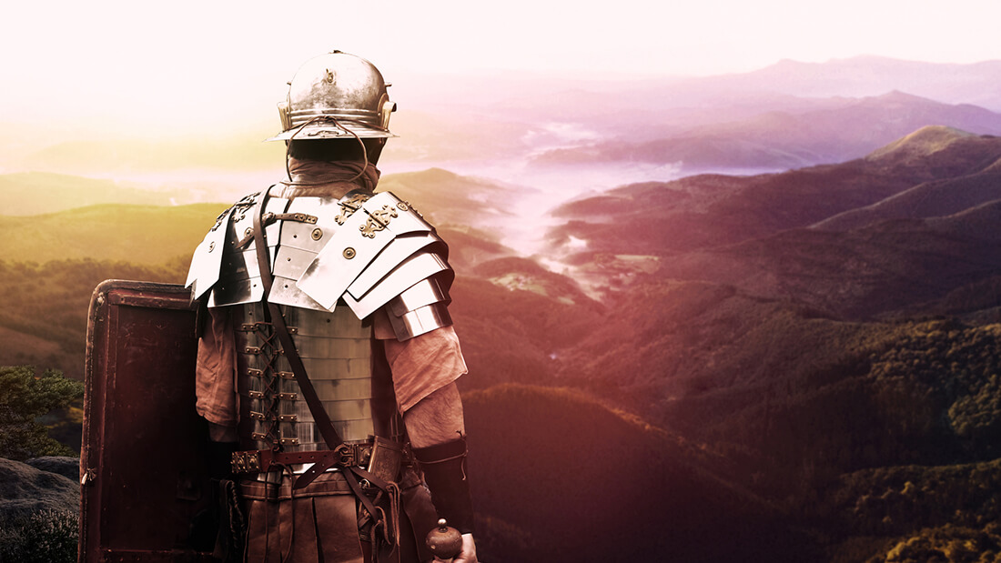A person in armor looking out over the mountains.