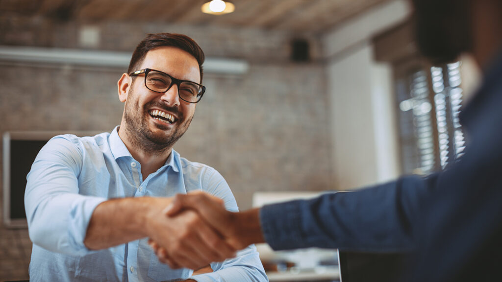 Two people shaking hands in a room.