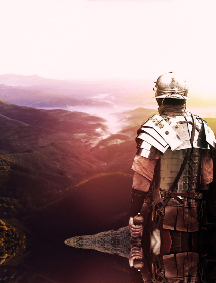 A man in armor looking out over the mountains.