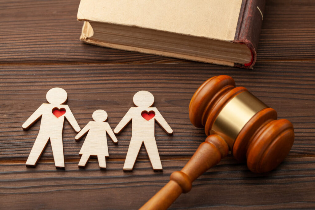 A family with one red heart is sitting next to a judge 's gavel.