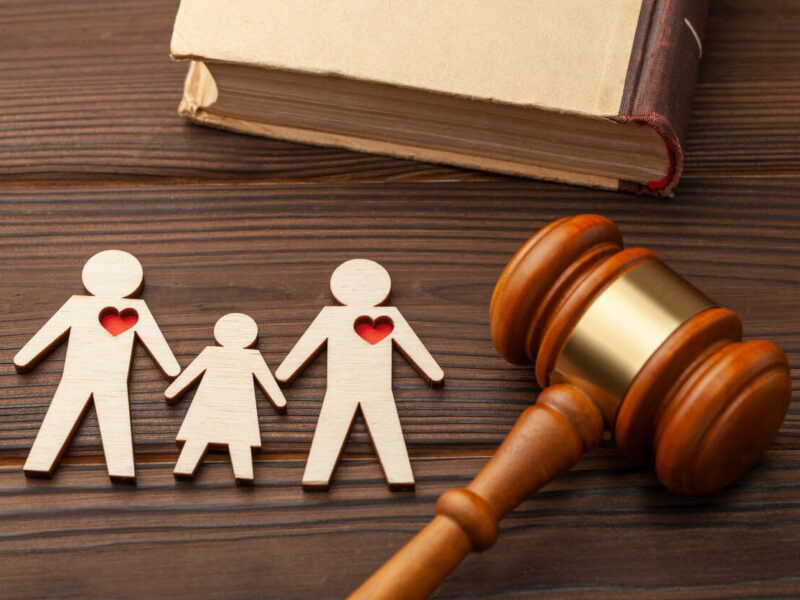 A family with one red heart is sitting next to a judge 's gavel.